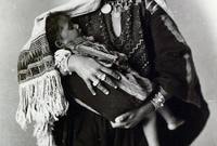 أم تحمل ابنها وهي ترتدي اللباس الفلسطيني التقليدي من المصور الفلسطيني الكبير "خليل رعد" 
