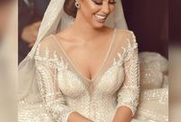 وظهرت رنا بفستان زفاف ملكي بلون "الشامبين"، تميز بأنه "منفوش" وفضفاض وبذيل طويل ومزين بنقوش فضية لامعة 
