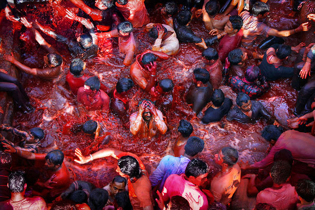 الهندوس يغمرون أنفسهم في بركة مليئة بالمياه الملونة في الهند
