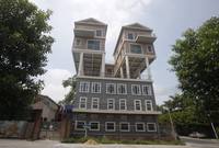 منزل كبير يحمل منزلين أخرين على سطحه في دونغقوان بمقاطعة قوانغدونغ، وبناؤه على الأرجح لم يكن قانونيا