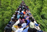 آلالاف المسافرون على سطح قطار مكتظ عائديين للاحتفال بعيد الفطر مع عائلاتهم.